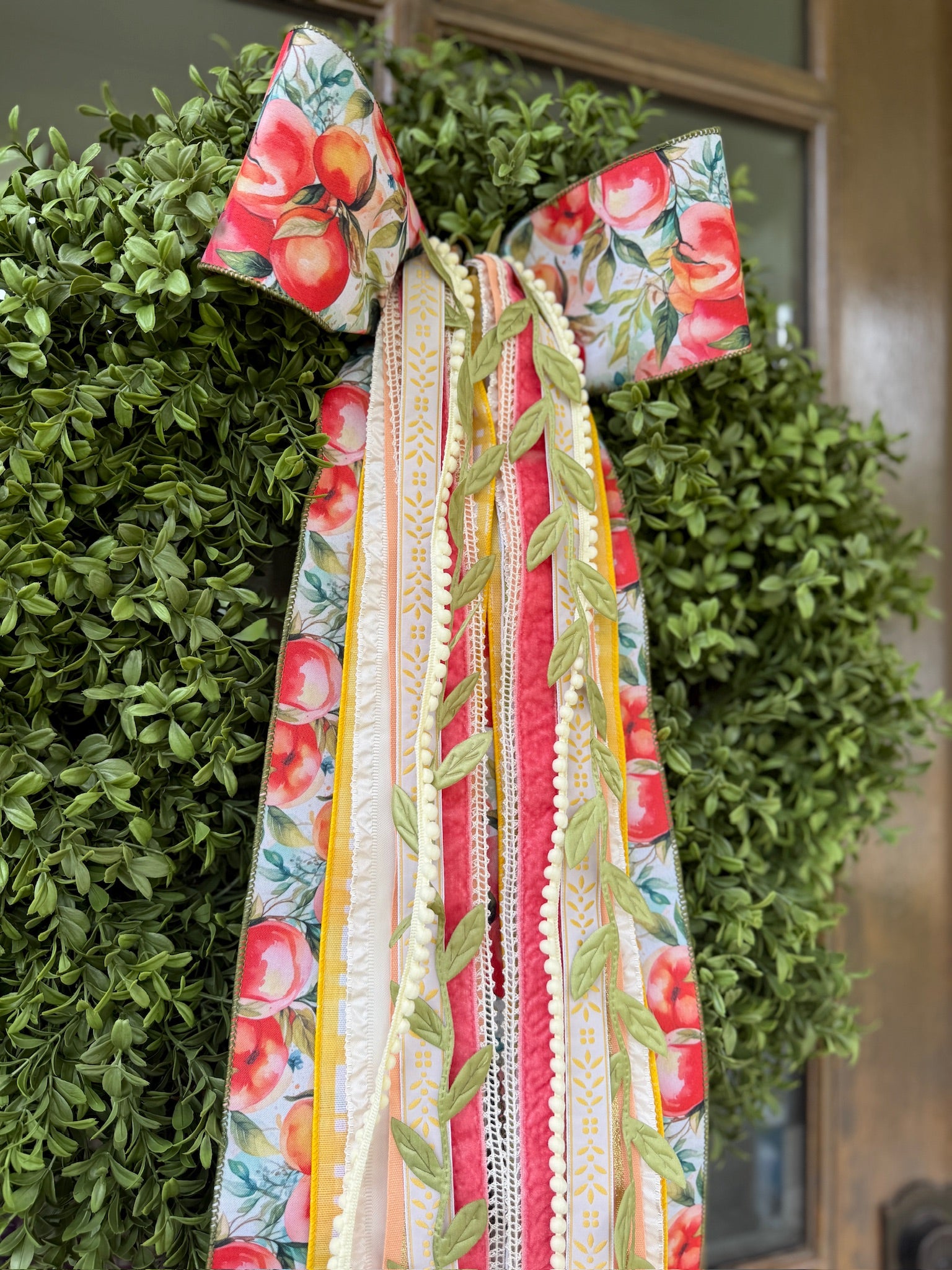 Patriotic plaid bow and ribbon wreath on green leaves