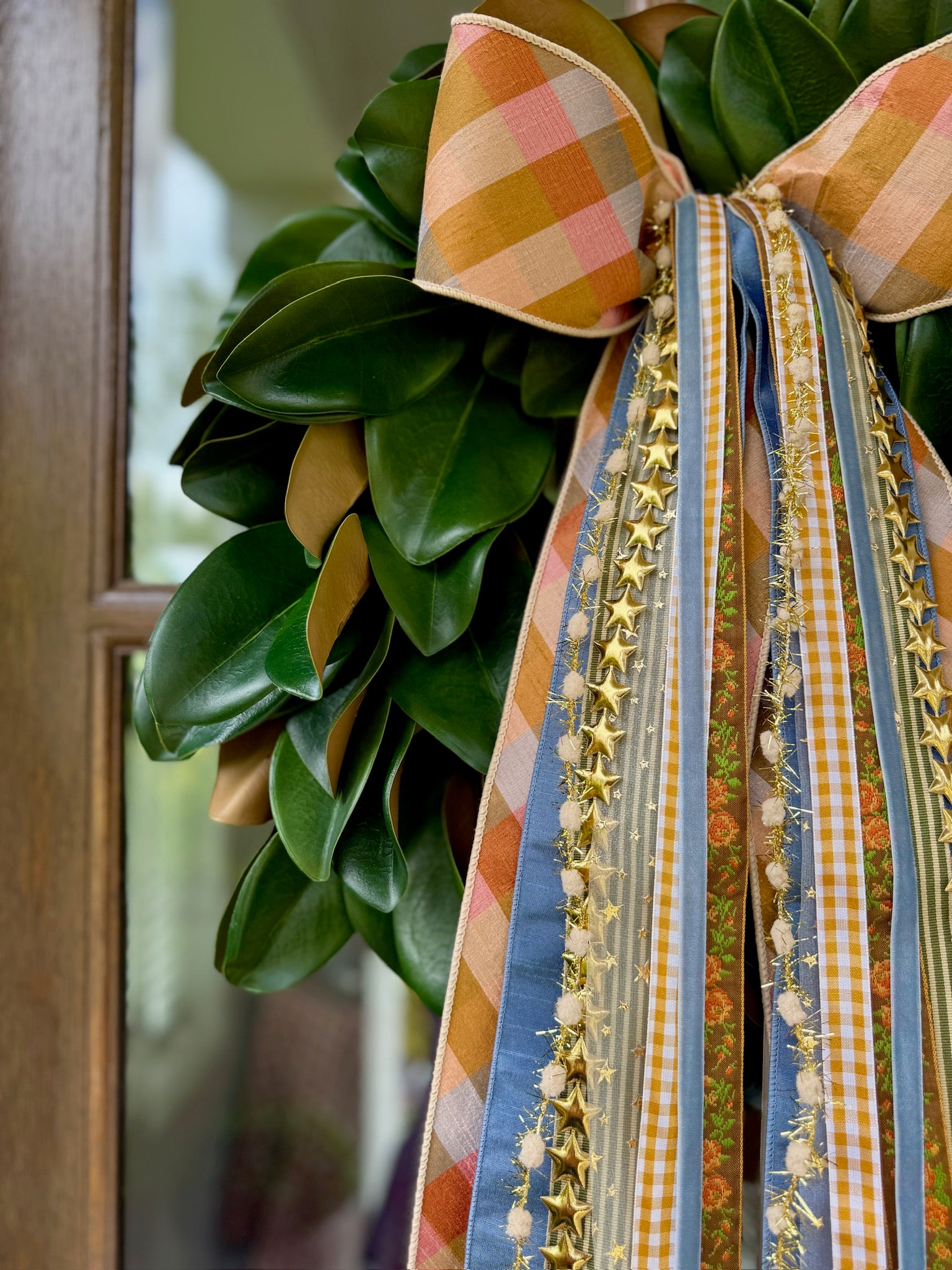 Patriotic plaid bow and ribbon wreath on green leaves